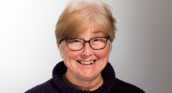 A headshot of Kim Hutchings in a navy polo neck jumper
