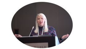 A picture of Dr Laura White speaking at a lectern.