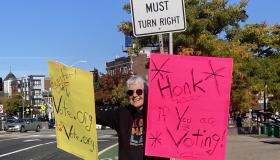 Cynthia Enloe at a voting rally holding up placards