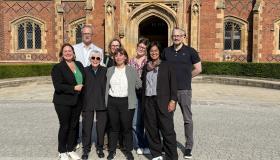Cynthia enloe posing for a picture with various BISA and QUB delegates in front of QUB quad opening 