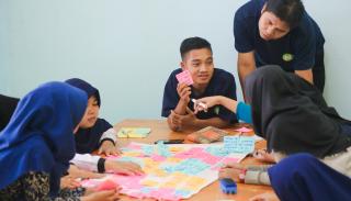 Students having a discussion around a table with coloured notecards on it