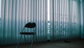 Single chair in an empty, dimly lit room