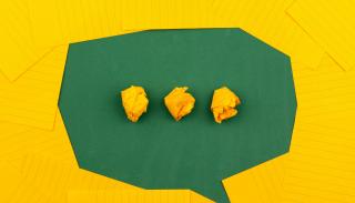 Speech bubble made from yellow index cards on a green table