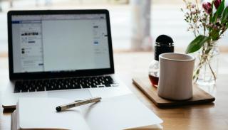 Photo of a laptop, notebook and mug