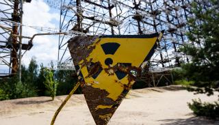 A rusted radioactive warning sign outside of Chernobyl