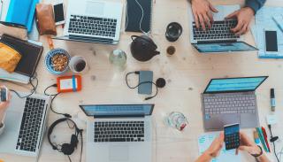 A table with laptops and coffee cups on