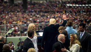 Donald Trump waving at a crowd with Joe Biden in the foreground