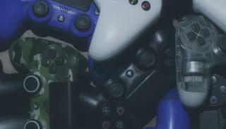 Multiple Xbox controllers each of different colours and prints photographed together.