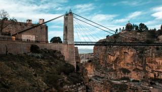 An image of a bridge stretched across a rocky ravine.