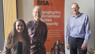 Working group convenors posing in front of a BISA banner