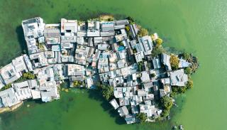 A country shaped image made out of a development huts on top of a green body of water