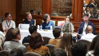 A panel at the Europa Hotel during #BISA2025, consisting of five panelists and a full auditorium