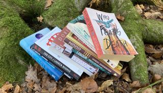 Photograph of some books fanned out on a tree's roots