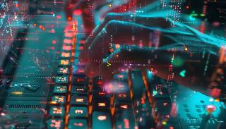 Hands typing on an LED-lit keyboard