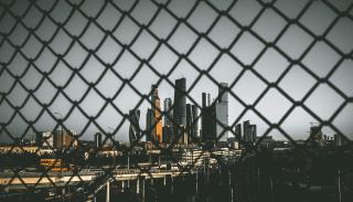 A chain fence with a city skyline behind