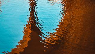 A pool of water reflecting a brown and orange shadow