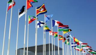 various world flags in a row against a blue sky