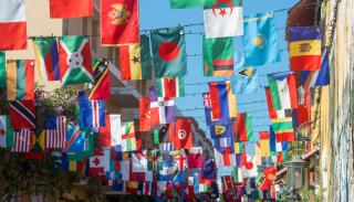 A courtyard with strings of different countries flags hung up between the two sides of the courtyard