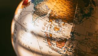 Multicoloured wooden globe dappled in sunlight 