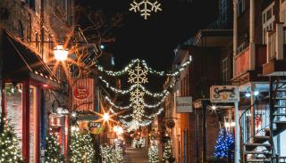 A city street decorated with festive lights in the evening