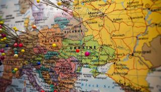 Multicoloured close up shot of a map with multicoloured pins inserted into it