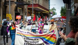 LGBTQ+ march holding a banner with the words equality without exemptions 