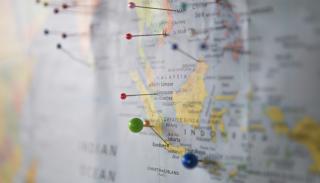 close up of map with multicoloured pins inserted into it 