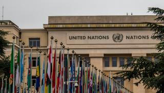 UN building with rows of different countries flags in front of it 