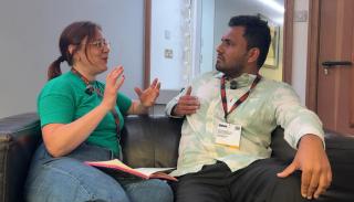 Lauren Rogers and Anand Sreekumar sat on a sofa having a conversation