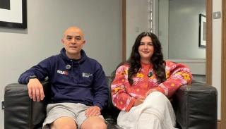 Andy Hom and Susy Williams sat on a sofa having a conversation