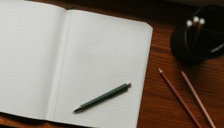 a notebook with a pen laying on top