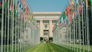 walkway up to the UN general assembly with rows of flags either side 