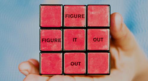 A red rubric cube that says 'figure it out' horizontally and vertically