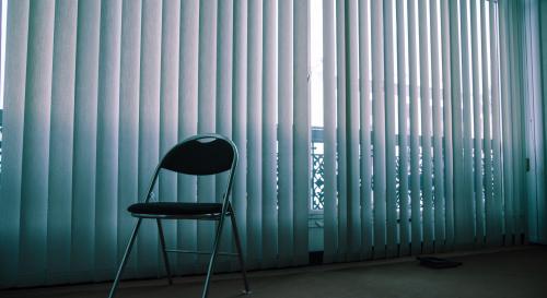 Single chair in an empty, dimly lit room