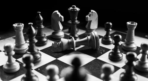 Chess pieces in a circle with the king knocked down