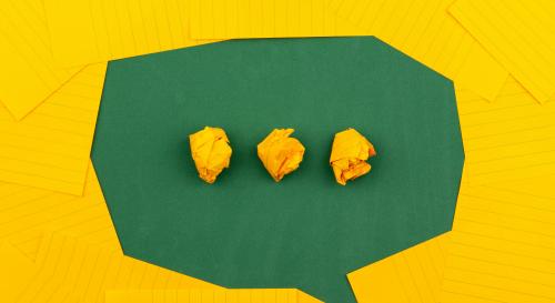 Speech bubble made from yellow index cards on a green table