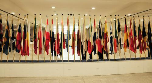 A line up of various countries flags in a hallway 