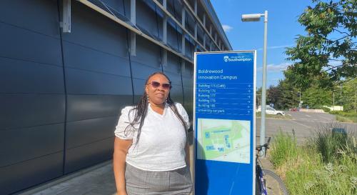 Margaret Ifeoma Abazie-Humphrey outside Southampton University next to a blue University sign