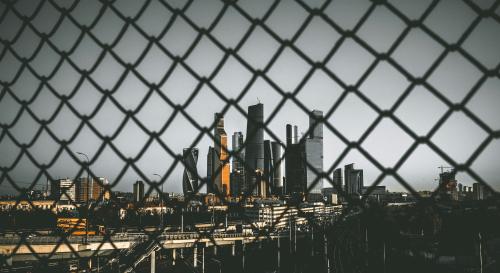 A chain fence with a city skyline behind