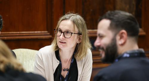 Juanita Elias sat at a table, speaking in a meeting
