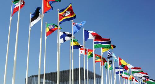 various world flags in a row against a blue sky