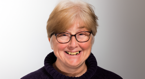 A headshot of Kimberly Hitchings wearing a navy polo neck jumper