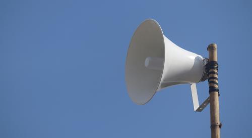 white megaphone on a pole with the blue sky as a background