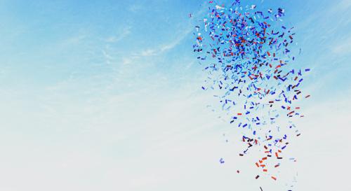 a person shooting a confetti cannon into the blue sky