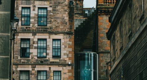 Cobbled road leading up to a brown brick building with a Scottish flag
