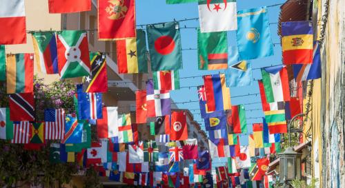 A courtyard with strings of different countries flags hung up between the two sides of the courtyard