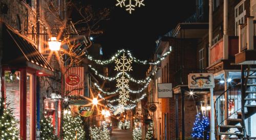 A city street decorated with festive lights in the evening