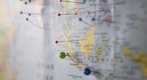 close up of map with multicoloured pins inserted into it 