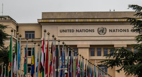 UN building with rows of different countries flags in front of it 