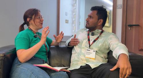 Lauren Rogers and Anand Sreekumar sat on a sofa having a conversation